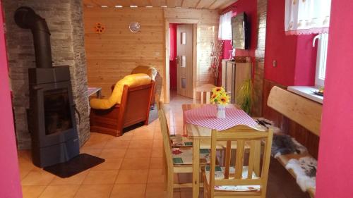 a living room with a table and a fireplace at Liptovská Chata pri potoku in Liptovský Mikuláš