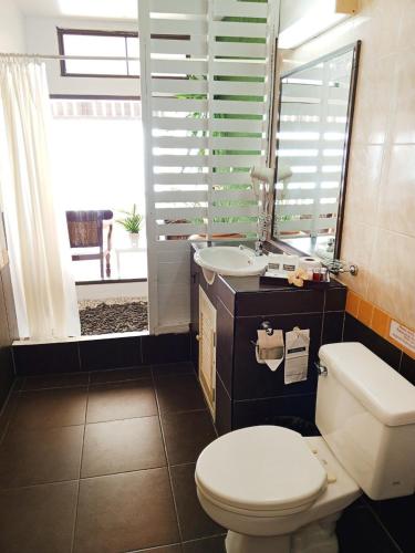 a bathroom with a toilet and a sink with a window at Koh Ngai Cliff Beach Resort in Ko Ngai
