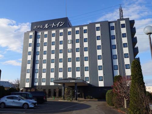 a building with a car parked in front of it at Hotel Route-Inn Yonezawa Ekihigashi in Yonezawa