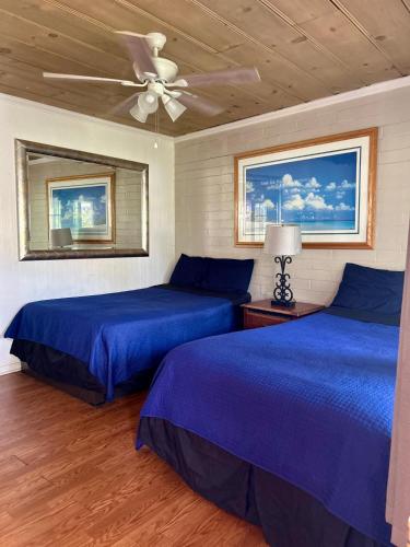 a bedroom with two beds and a ceiling fan at Oceana Boutique Hotel in San Clemente