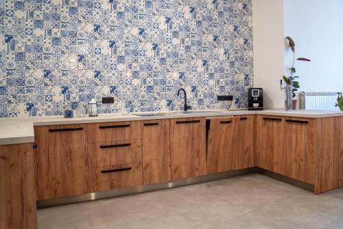 a kitchen with wooden cabinets and a tile wall at Penzion u Karla in Jamolice
