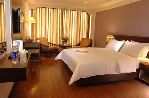 a hotel room with a large bed and a desk at CAG Pride in Coimbatore