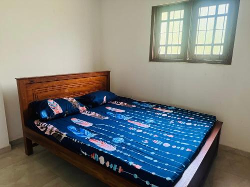 a bed with a blue comforter on it in a bedroom at Matara Villa in Matara