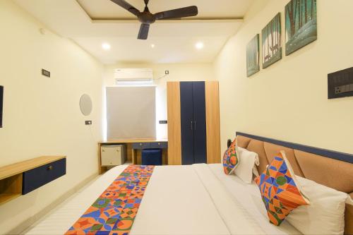 a bedroom with a bed and a ceiling fan at FabHotel Lake View Castle in Warangal