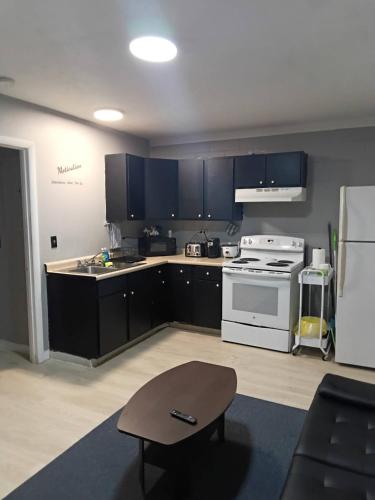 a kitchen with black cabinets and a white stove at Cosy single-level home with laundry and parking in Huntington