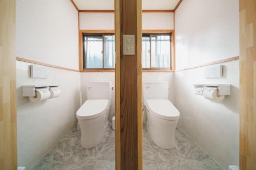 a bathroom with two toilets and two windows at アリュール照波園 in Beppu