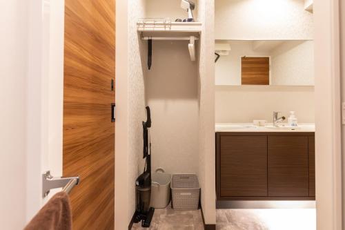 a bathroom with a sink and a toilet and a door at ReLA Kashiwa Eki Mae in Kashiwa