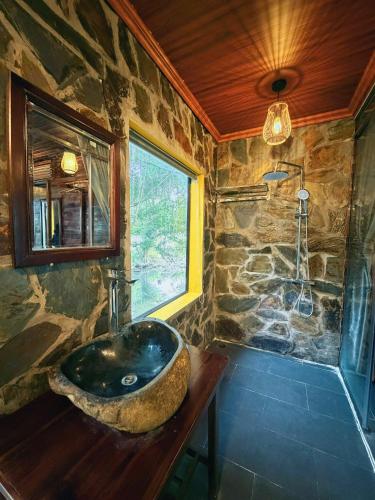 a stone bathroom with a sink and a window at Trang An Mountain River Ecolodge in Ninh Binh