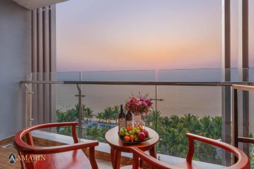 a room with a table with fruit and a view of the ocean at Amarin Resort & Spa Phu Quoc in Phú Quốc