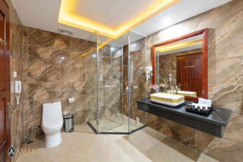a bathroom with a shower and a toilet and a sink at Amarin Resort & Spa Phu Quoc in Phú Quốc