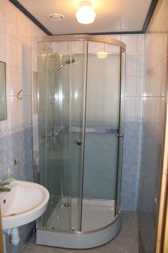 a bathroom with a glass shower and a sink at Trosa Vandrarhem in Trosa