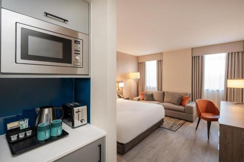 a hotel room with a bed and a living room at Hyatt House Aparthotel Leeds in Leeds