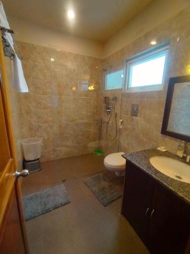 a bathroom with a toilet and a sink and a shower at amã Stays & Trails Eagle's Nest, Gangtok, Sikkim in Bhurtuk