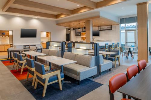 a restaurant with tables and chairs and a bar at Hyatt House Fresno/Campus Pointe in Fresno
