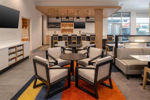 a restaurant with tables and chairs and a bar at Hyatt House Fresno/Campus Pointe in Fresno