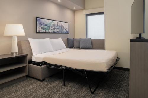a hotel room with a bed and a television at Hyatt House Fresno/Campus Pointe in Fresno