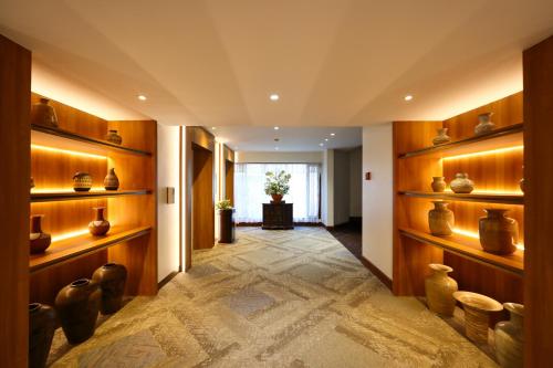 a hallway with vases on shelves in a building at Wienglakor Hotel Lampang in Lampang