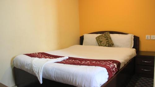 a small bed in a room with orange walls at Bhuwani Himalayan Height Hotel in Kathmandu