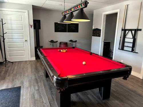 a pool table in a room with a red cover at Lakefront - Chalet Le Missionnaire in Trois Rives