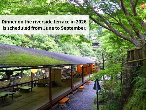 a restaurant in a forest with benches and trees at Takao Kanko Hotel in Kyoto