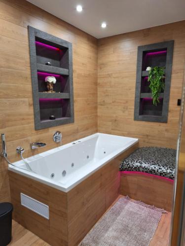 a bath tub in a bathroom with wooden walls at Vila pod Dubem in Návsí u Jablunkova