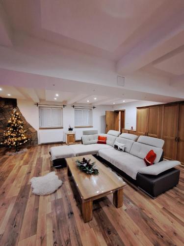 a living room with a couch and a christmas tree at Vila pod Dubem in Návsí u Jablunkova