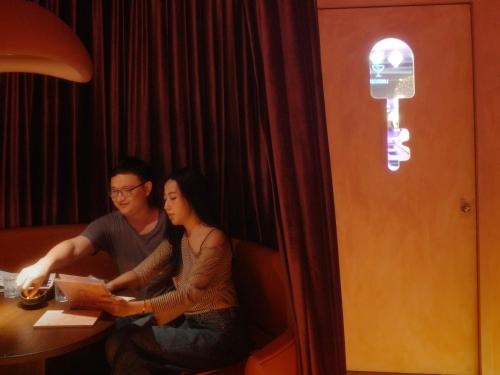 a man and a woman sitting at a table at Nimman Mai Design Hotel Chiang Mai in Chiang Mai