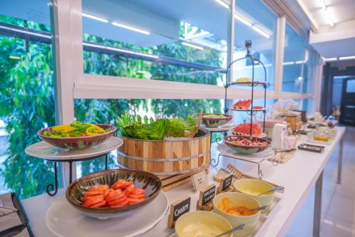 a buffet line with bowls of vegetables and other foods at Nimman Mai Design Hotel Chiang Mai in Chiang Mai