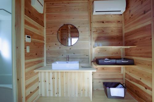 a wooden bathroom with a sink and a mirror at Shinon 森音 in Tateyama