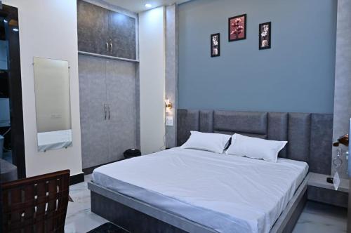 a bedroom with a large bed with white sheets at Hotel Radhe in Bhind