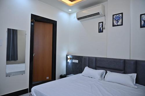 a bedroom with a bed and a brown door at Hotel Radhe in Bhind