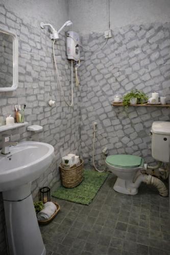 a bathroom with a shower and a toilet and a sink at Solar House Hotel in Dickwella