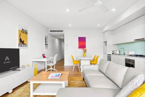 a living room with a couch and a table at Central luminous 2 beds with balcony & aircon in Sydney