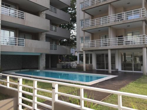 un edificio de apartamentos con piscina frente a él en Solo Pinamar en Pinamar