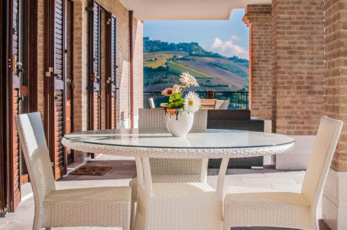 a table with chairs and a vase of flowers on a patio at Moresco Agriturismo in Moresco