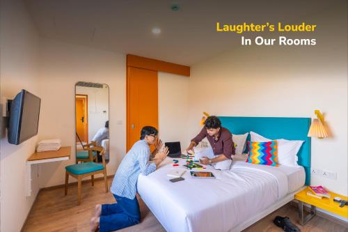 two people sitting on a bed in a room at goSTOPS Bengaluru, Jayanagar - Private Rooms & Dorms in Bangalore