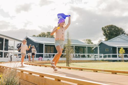 a little girl jumping on a wooden boardwalk at Tasman Holiday Parks - Miranda in Miranda