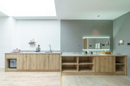 a kitchen with wooden cabinets and a sink and a mirror at Xianzai Houshe Boutique Hotel in Dujiangyan