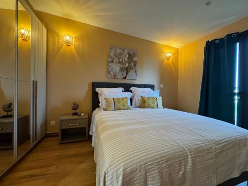a bedroom with a large white bed with two pillows at Le Passamainty Lodge in Mamoudzou