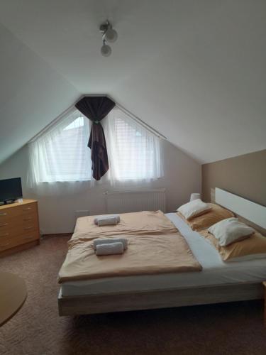a bedroom with a large bed and a window at Holiday Apartman in Bük