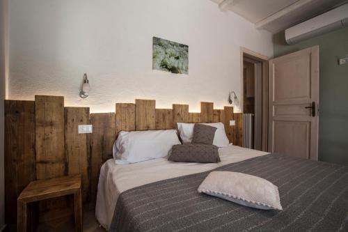 a bedroom with a large bed with a wooden headboard at Casa Al Fiume in Ponti Sul Mincio