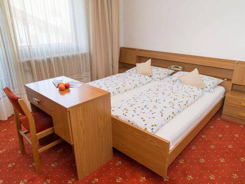 a bedroom with a bed and a table and a desk at Haus Elisabeth in Nova Ponente
