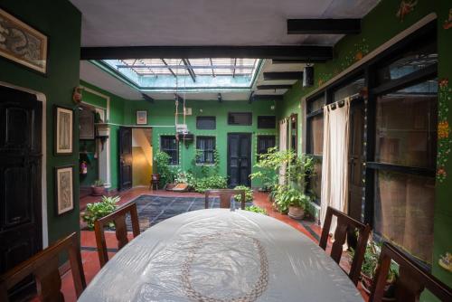 a room with green walls and a large white table at Ram Bhawan Residency in Varanasi