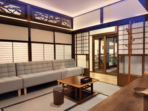 a living room with a couch and a table at Three Maples Fujiyoshida in Fujiyoshida