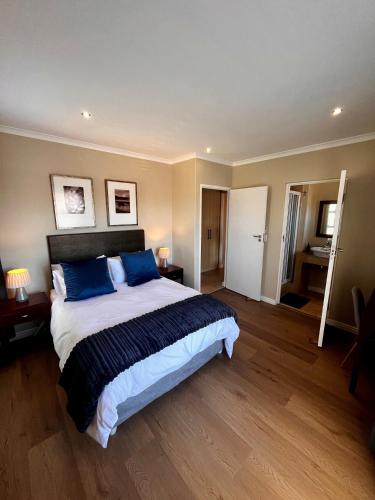 a bedroom with a large bed with blue pillows at Hill Fore! in Langebaan