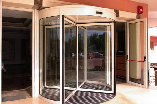 an aluminium revolving door on the side of a house at Monte Carlo Palace Rooms in Bucharest