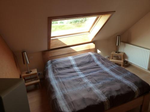 a bedroom with a bed with a window in it at Vakantiehuis 'De Wulpenbrug' in Wulpen