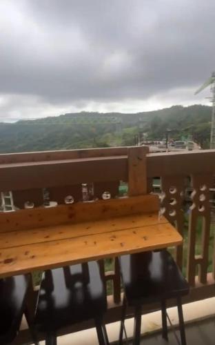 a wooden bench sitting on top of a balcony at Twin Lakes Tagaytay Staycation by JC Staycation in Balibaguhan