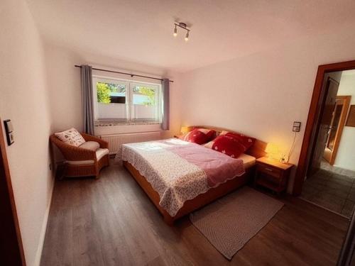 a bedroom with a bed and a chair and a window at Lüttje Tied in Walsrode
