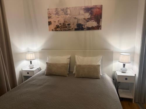 a bedroom with a bed with two nightstands and two lamps at V71A Kauno Centre in Kaunas